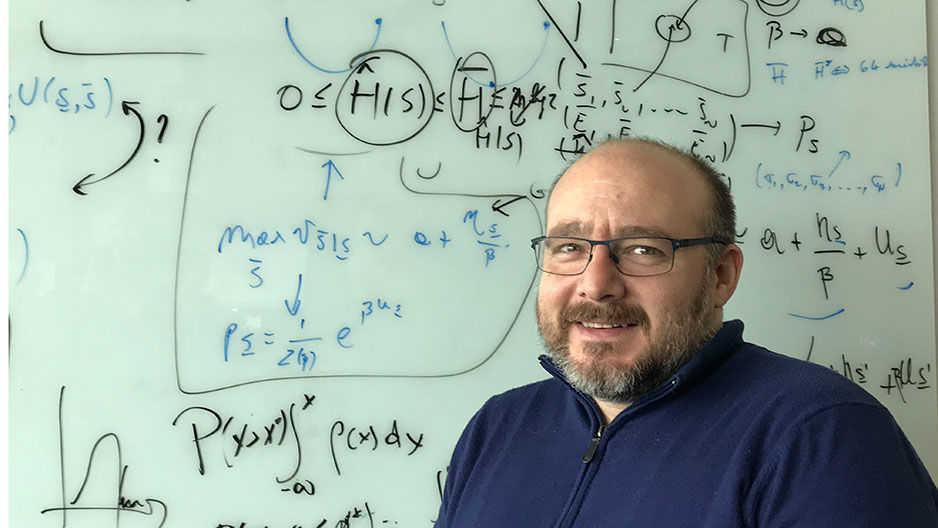 Associate Professor of Biology Vincenzo Carnevale in front of white board with equations