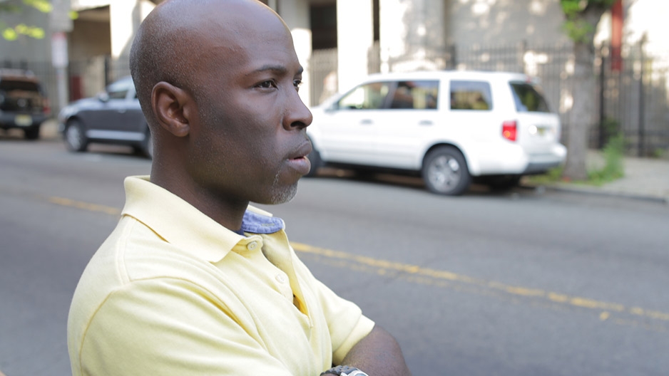 A man in a yellow shirt standing on a film set.