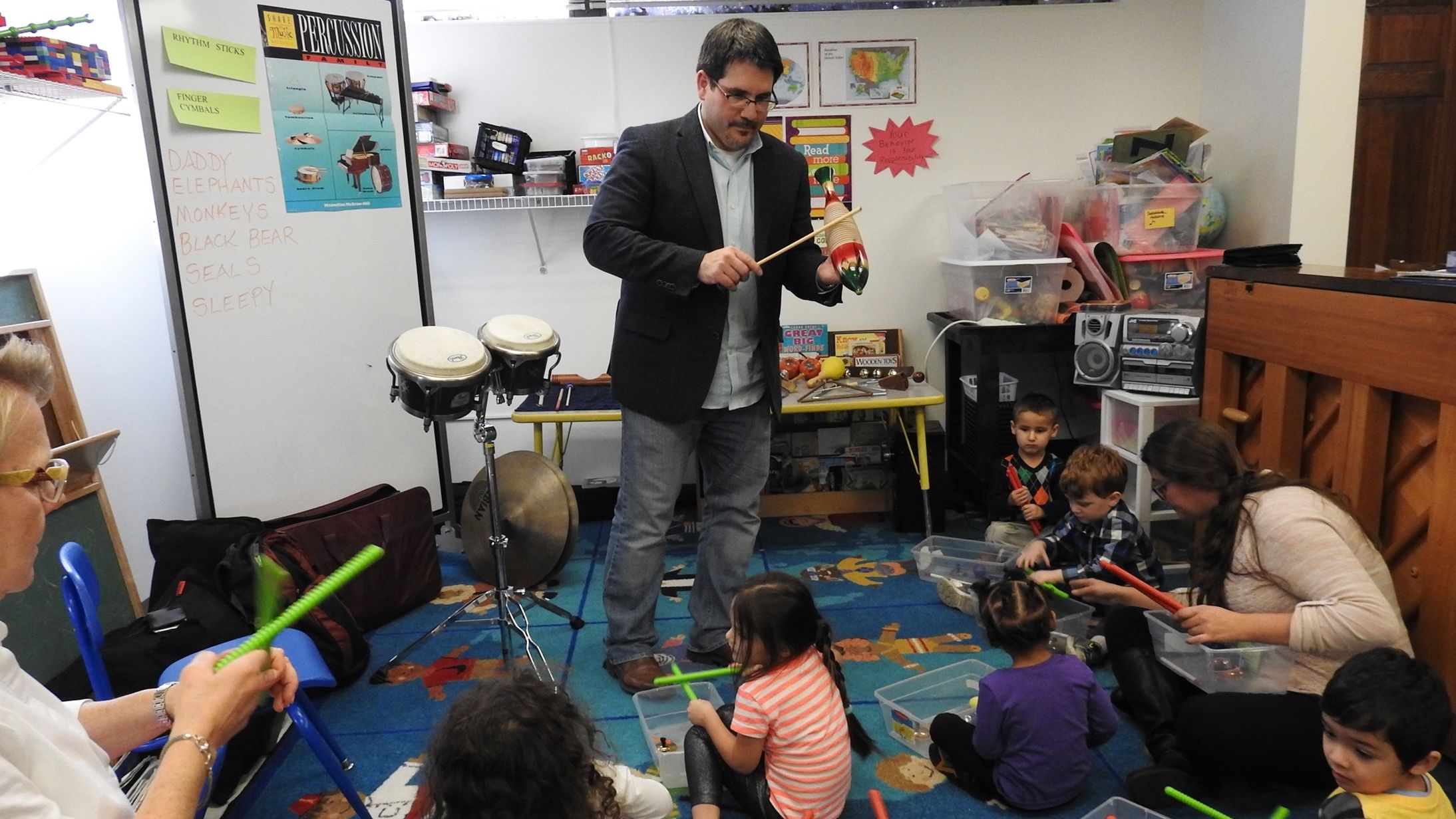 Steven Weiser, BYR ’02, ’04, teaches a percussion lesson to a group of students.