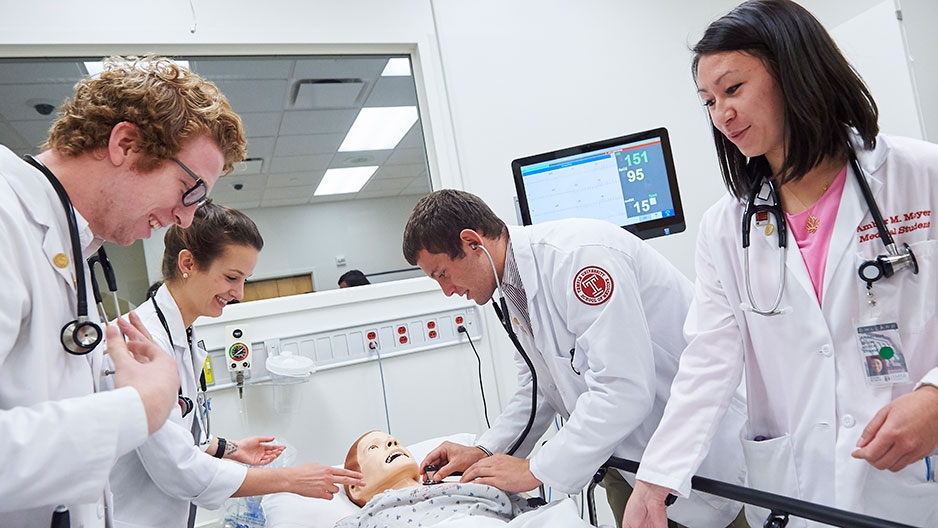 medical students practicing on a mannequin