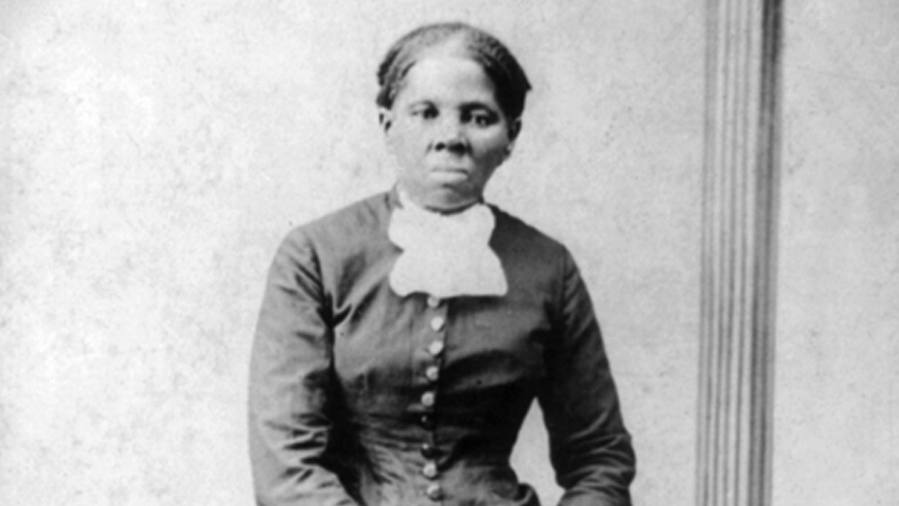 Image of Harriet Tubman standing against a chair.