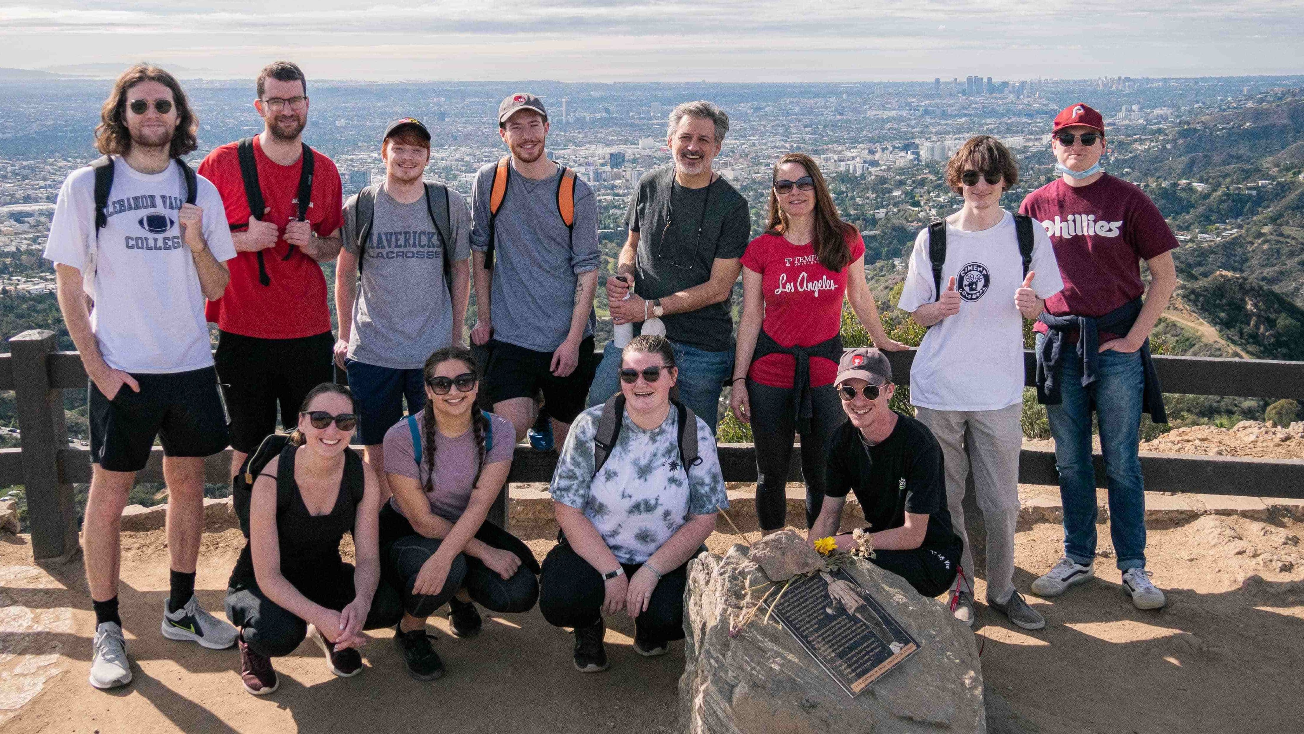 Image of students and faculty posing in front of a fence.