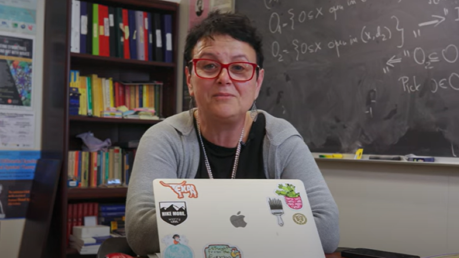 Dr. Irinia Mitrea sitting behind her laptop at her desk 