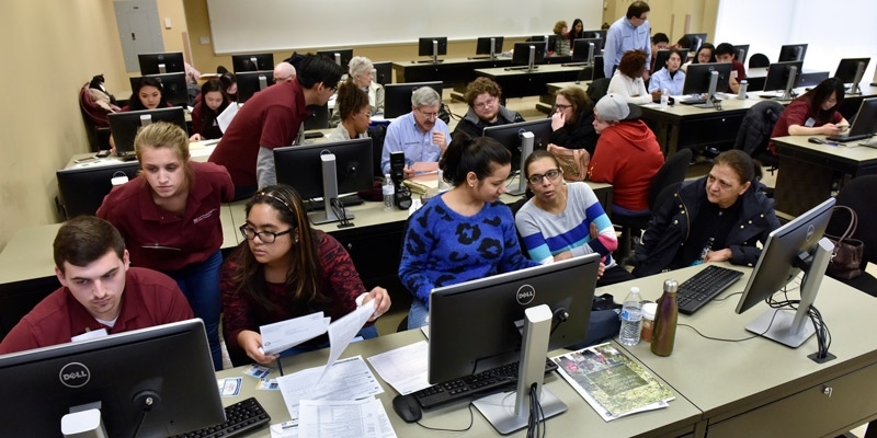 Temple students at computers helping residents file their taxes.