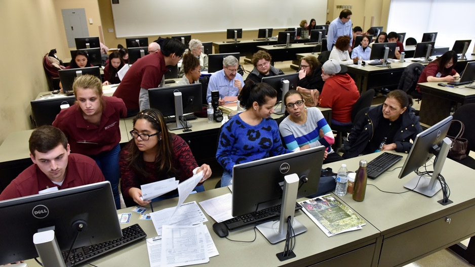 Temple students at computers helping residents file their taxes.