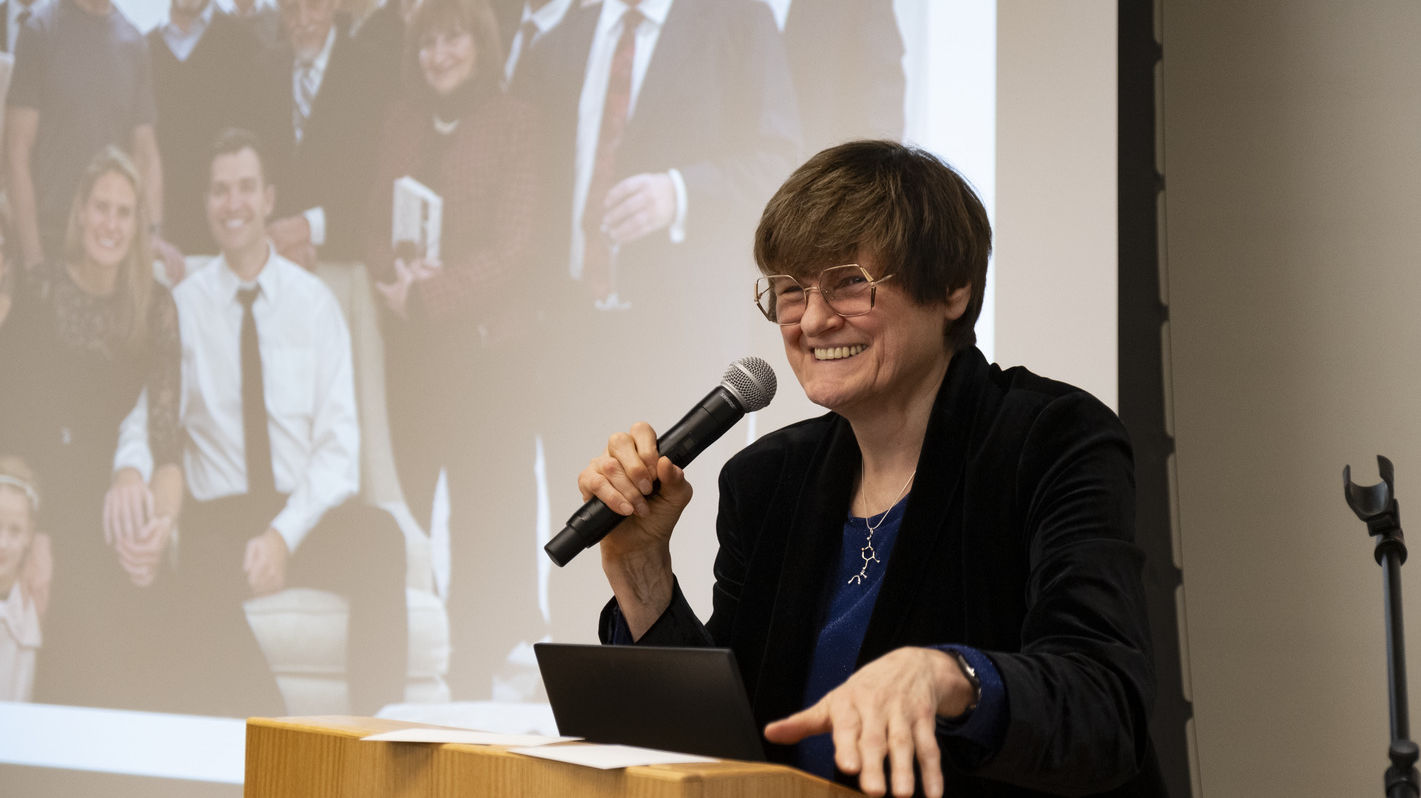 Dr. Kariko standing and speaking at a podium