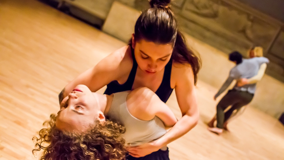 Two women dancers embracing.