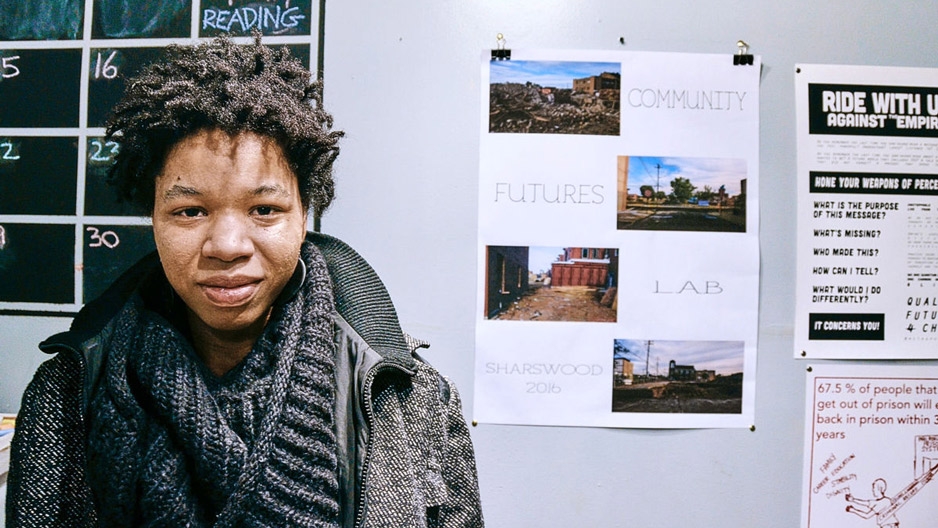 Rasheedah Phillips standing in front of a wall with a calendar and posters.
