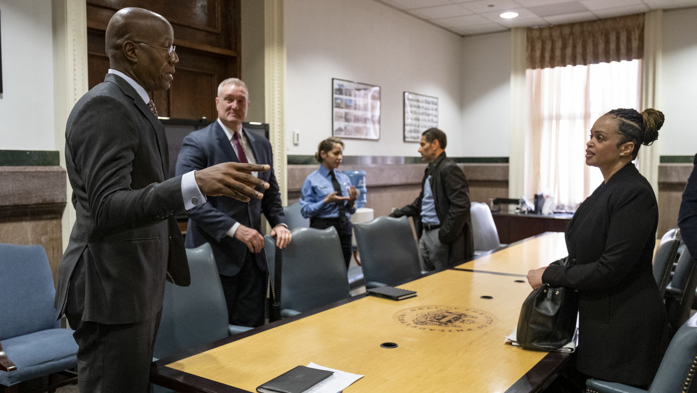 President Wingard speaks with Commissioner Outlaw at a long table