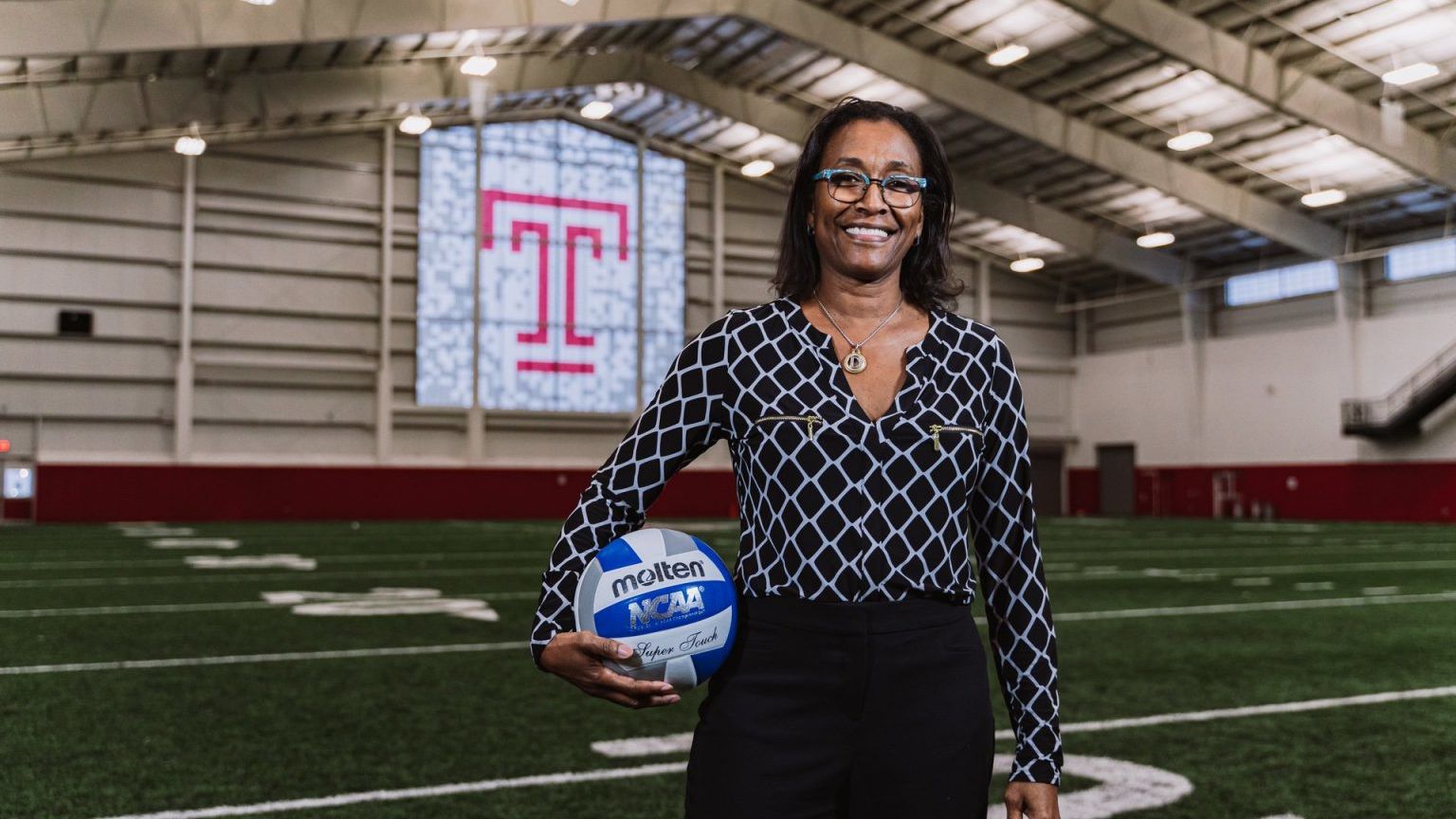 Associate Professor Debra Blair holding a ball on a Temple field