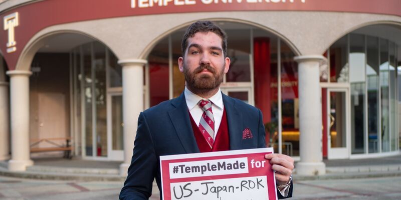 Soren holds sign saying “#TempleMade for US-Japan-ROK Trilateral Relationship” 