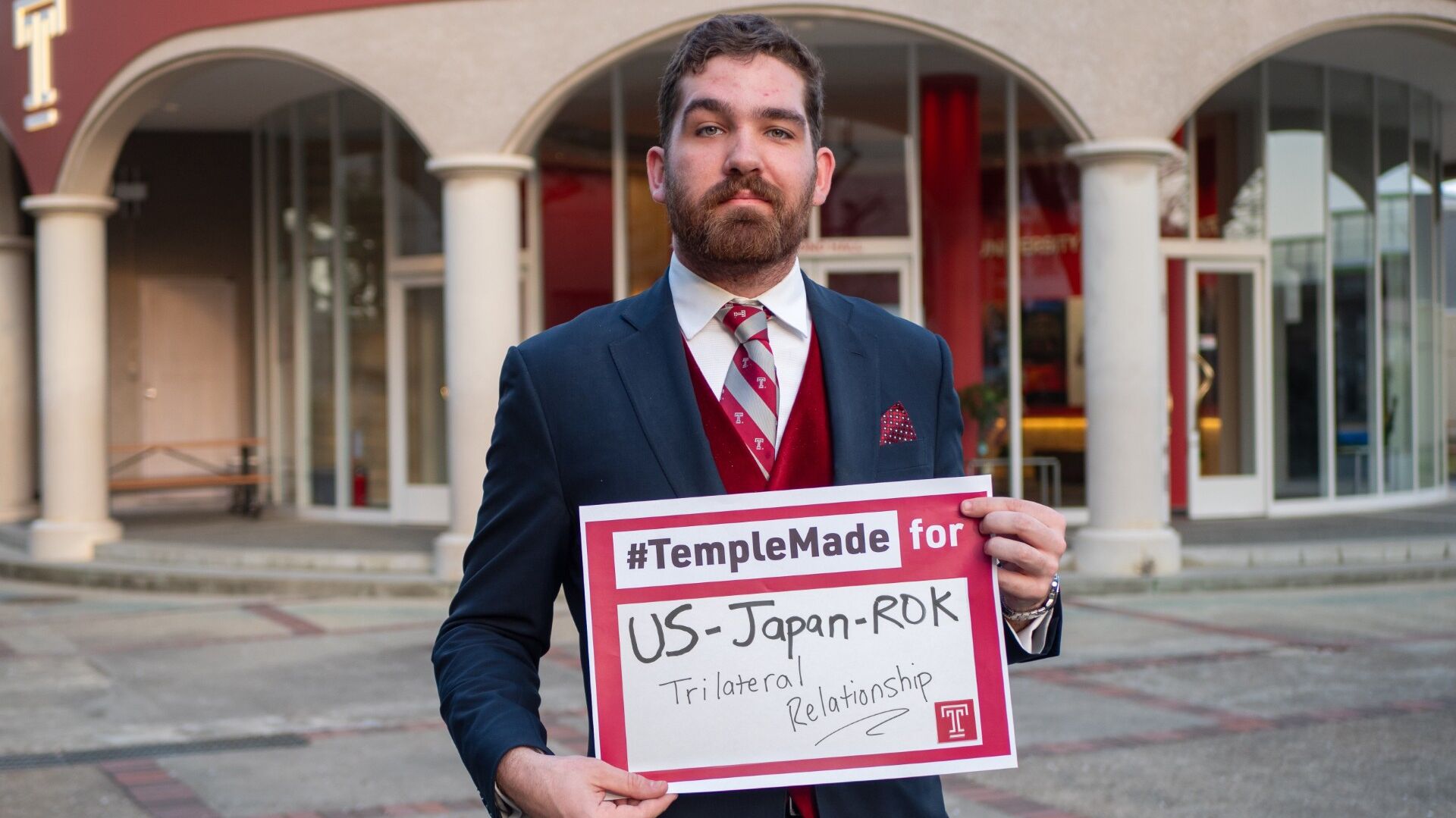 Soren holds sign saying “#TempleMade for US-Japan-ROK Trilateral Relationship” 
