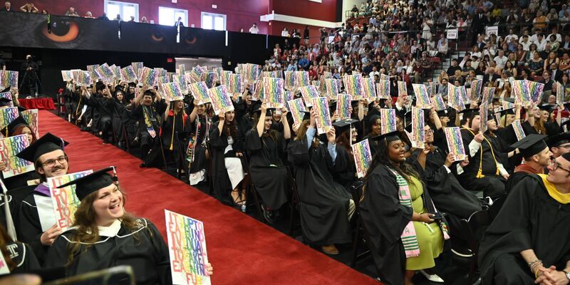 Tyler graduates holding up their Diploma Project print 