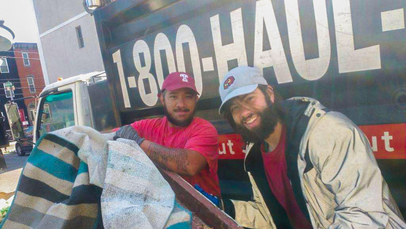 Image of two men wearing Temple branded hats in front of truck