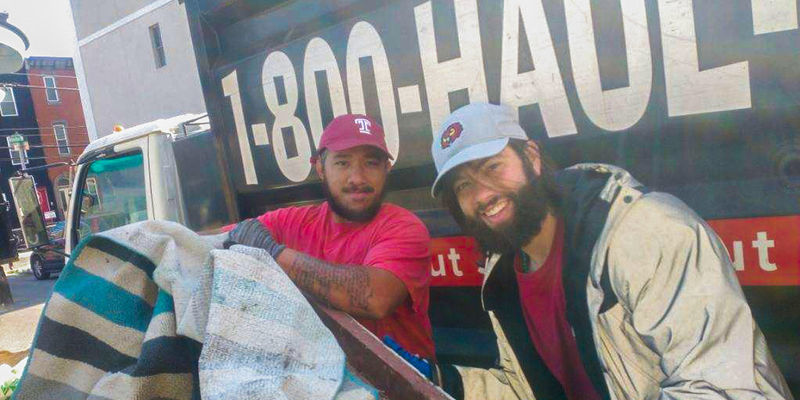  Image of two men wearing Temple branded hats in front of truck. 