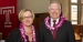 Elizabeth Bolman and President Neil D. Theobald wear flower leis and smile.