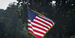 The American flag outside near trees