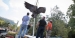 construction workers watch as a bronze owl statue is lowered