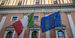 Image of the Italian and European flags on a building.