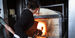 Temple faculty demonstrating glassblowing furnace