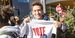 A Temple student holding a t-shirt that says vote