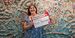 Abigail McNavage holding a #TempleMade sign in front of her painting