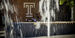 A student is pictured behind a fountain.