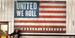 Brasten stands near an American flag that reads "United We Roll" and "Harley-Davidson."