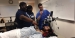 Two medical students showing middle school students a procedure in the hospital.