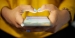 Hands typing on a cell phone.