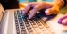 Hands resting on the keyboard of a laptop.