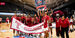 Image of Temple women’s basketball in the cherry and white celebrating on the court. 