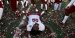 A Temple football player laying on the confetti covered field.