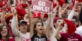 A group of students cheering at a Temple athletic event. 