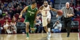 A Temple men’s basketball player dribbling a ball as a Tulane player defends.