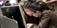 Two women sitting in front of a computer