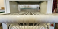White fabric spinning on a loom.