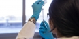 A researcher holding up a syringe