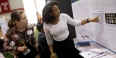 A student pointing to research published on her poster at the science fair.