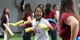 A student practicing her fencing technique with a yellow pool noodle.