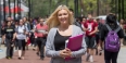 A blond woman holding books on Liacouras Walk.