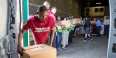 Temple men’s basketball players unloading a van at a food bank.
