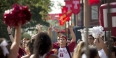 A group of students wearing Temple gear on campus. 