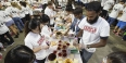 Students at a table making peanut butter and jelly sandwiches. 