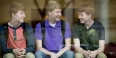 Three young men sitting and talking together. 