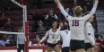 Temple's volleyball team cheering on the court.