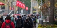 students walking on campus underneath red flags bearing the Temple ‘T’.