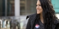 A woman smiling with an “I voted sticker” on her shirt. 