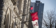 Temple flags hanging from the Temple Performing Arts Center with Morgan Hall in the background.