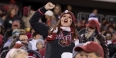 a fan in the crowd wearing Temple gear, cheering on the Temple football team.